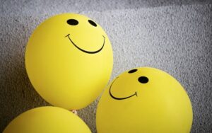 Three yellow balloons with a smiley face.